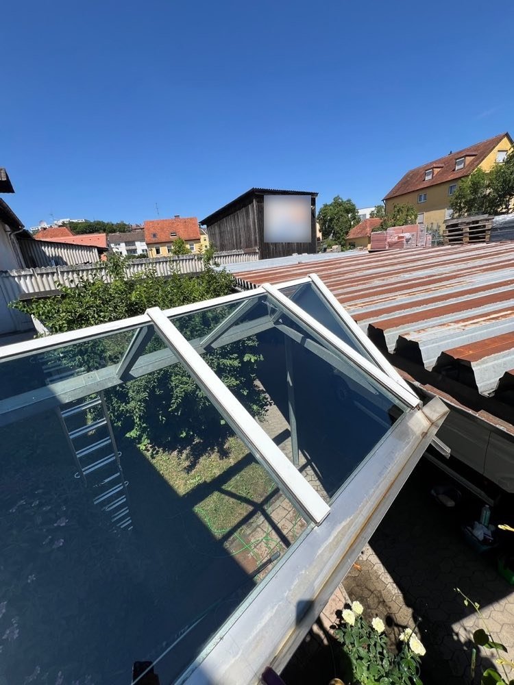 Gereinigtes Glasdach einer Terrasse unter blauem Himmel
